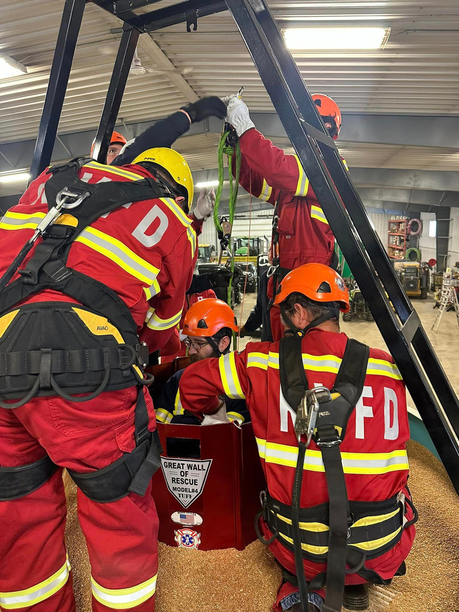 A group of firefighters in red uniforms working with a contraption.