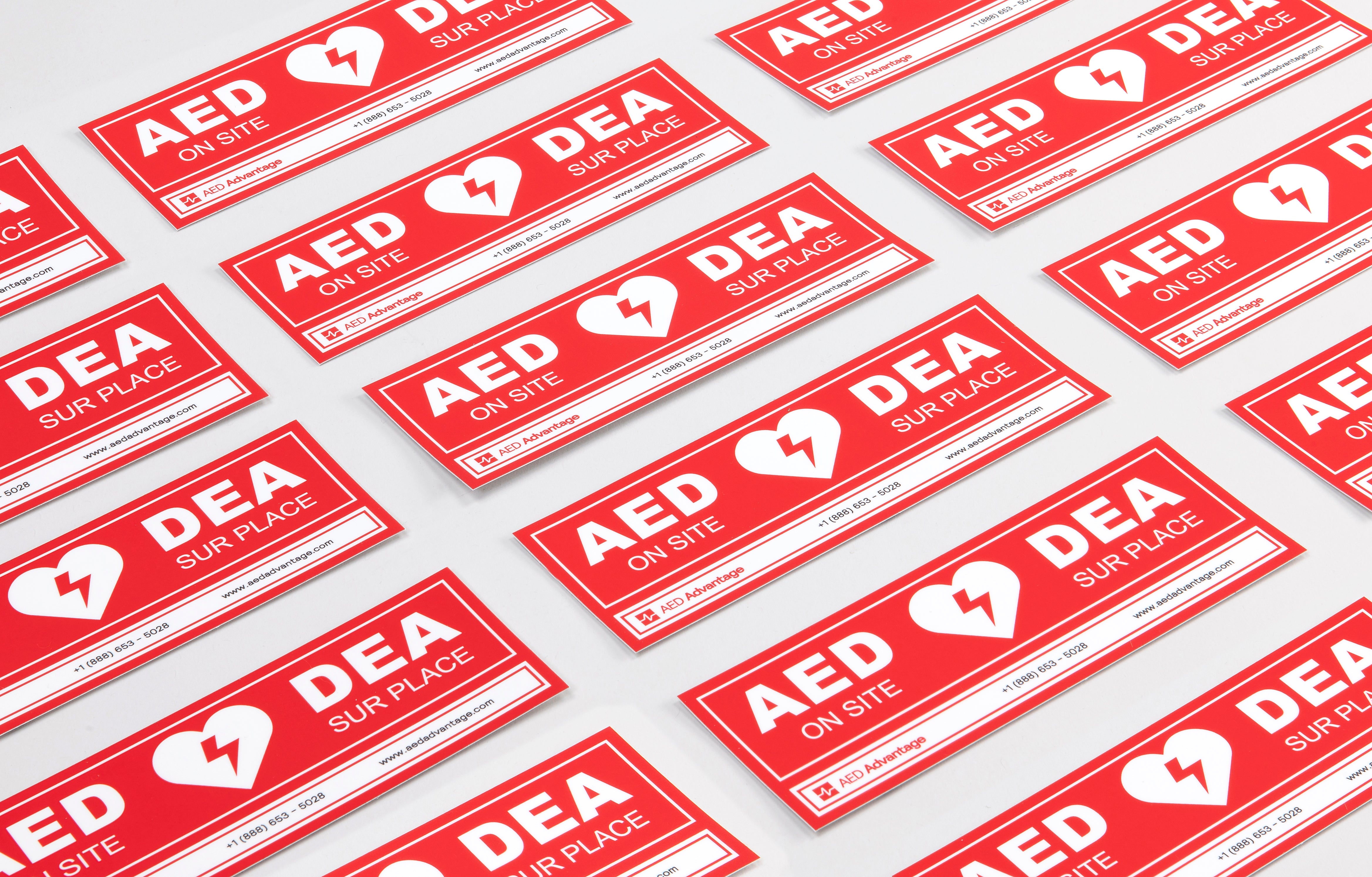 A collage of red rectangular decals that adhere to doors indicating an AED is present at a facility