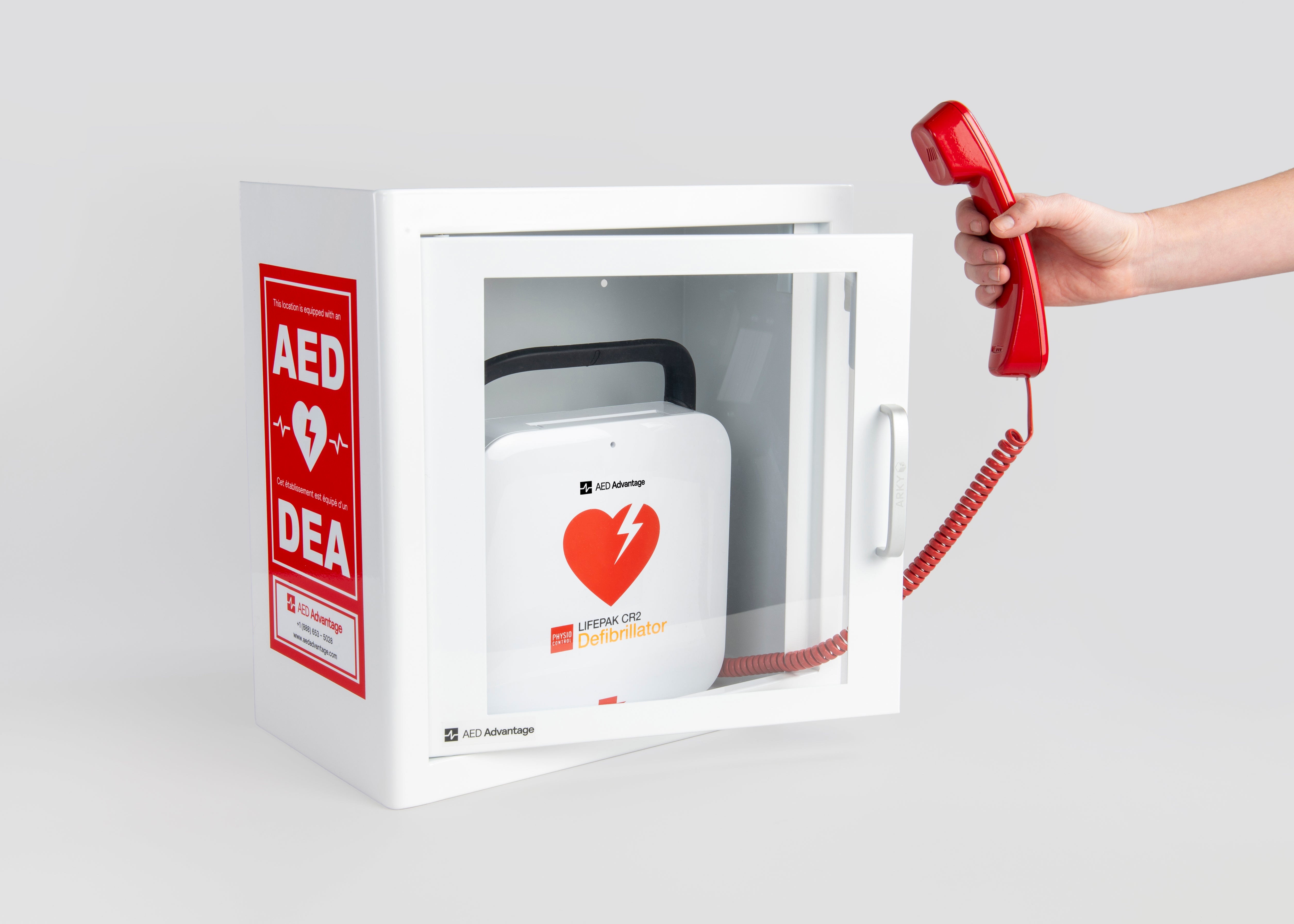 A phone being pulled out of a white and red AED cabinet made to look like a phone booth