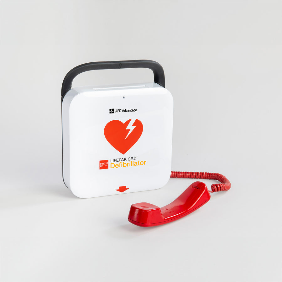 A LIFEPAK CR2 AED with bright red phone laying in front of it. 