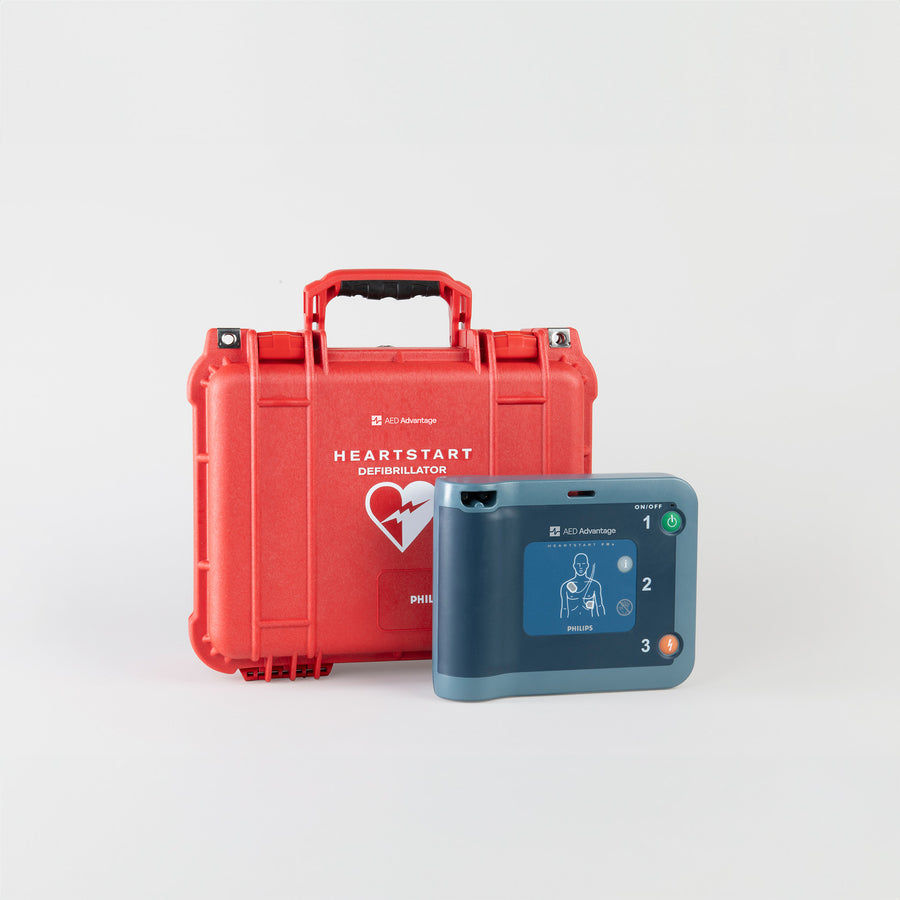 A blue Philips FRx AED standing next to a bright red hardshell carry case
