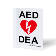 A bilingual white metal rectangular wall sign containing large bold text indicating an AED is present