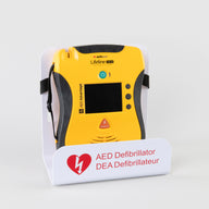 A black and yellow Lifeline VIEW AED displayed in a white metal wall mount bracket