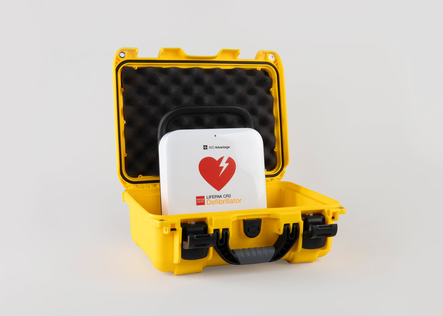 A white and red LIFEPAK CR2 AED machine inside a bright yellow hardshell carry case