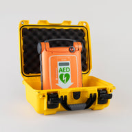 An orange Powerheart G5 AED inside a bright yellow hardshell carry case