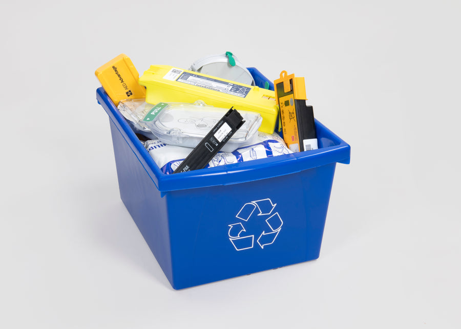 AED batteries of various colours inside a blue recycle bin