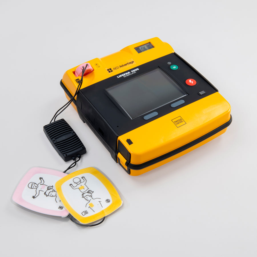 A black and yellow AED with infant electrodes plugged in