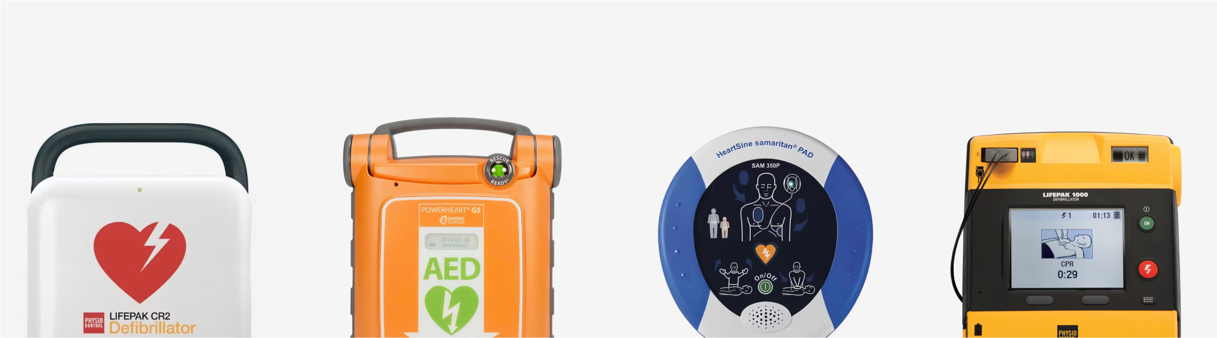 Four AEDs of various colors standing in a line