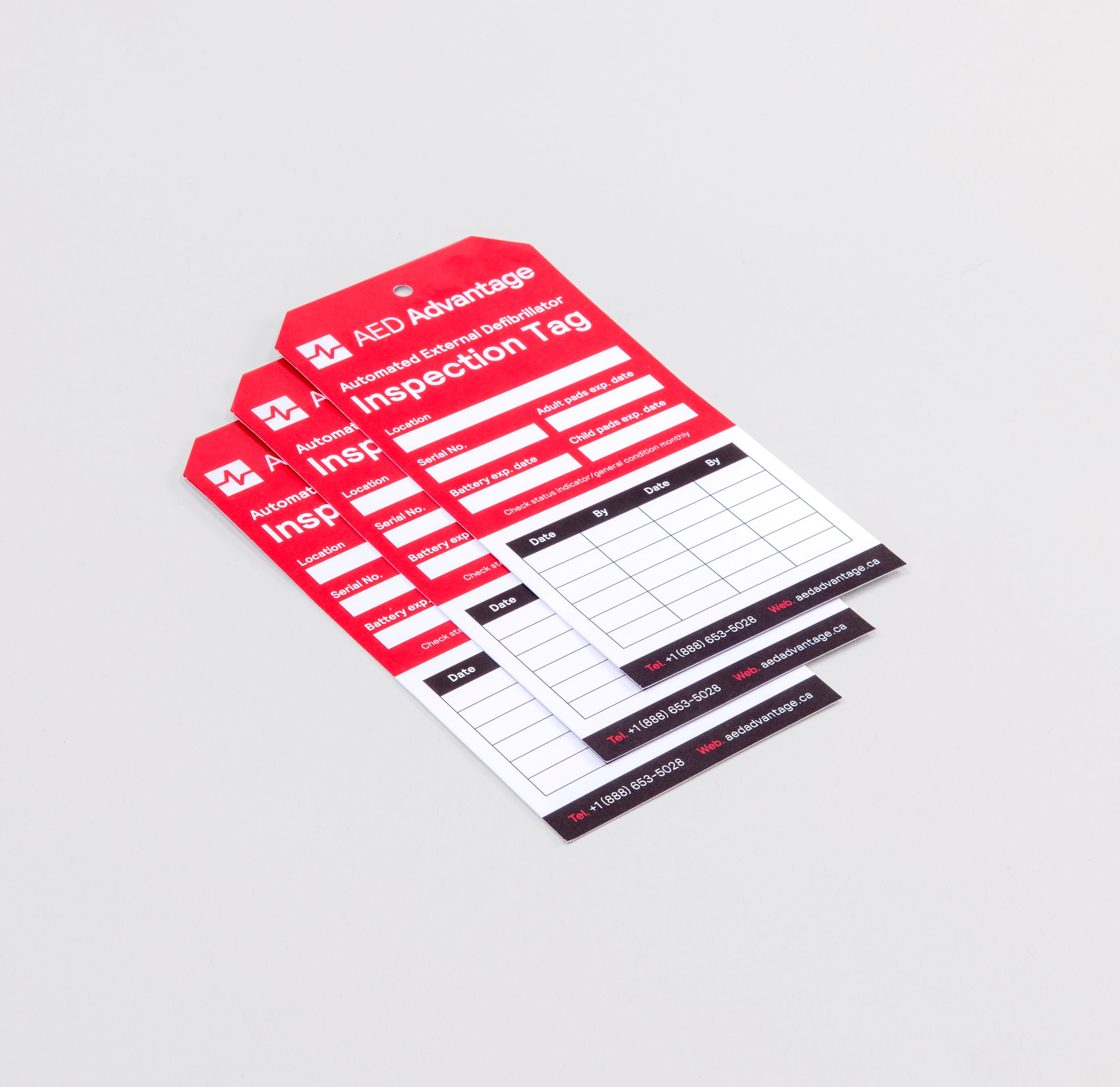 Three red and white tags meant for tracking defibrillator inspections