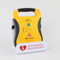 A black and yellow Lifeline AED displayed in a white metal wall mount bracket 