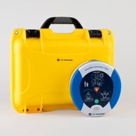 A blue and gray HeartSine 500P AED standing next to a bright yellow hardshell carry case.