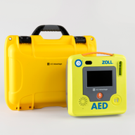 A green ZOLL AED 3 machine standing next to a bright yellow hardshell carry case