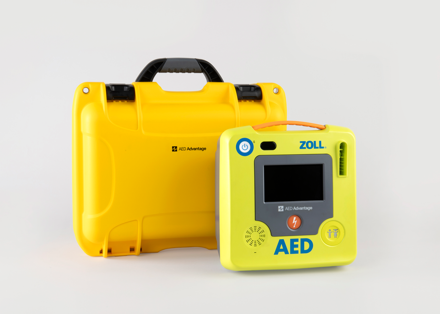 A green ZOLL AED 3 machine standing next to a bright yellow hardshell carry case