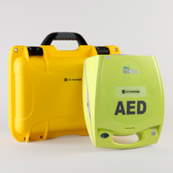 A green ZOLL AED 3 machine standing next to a bright yellow hardshell carry case