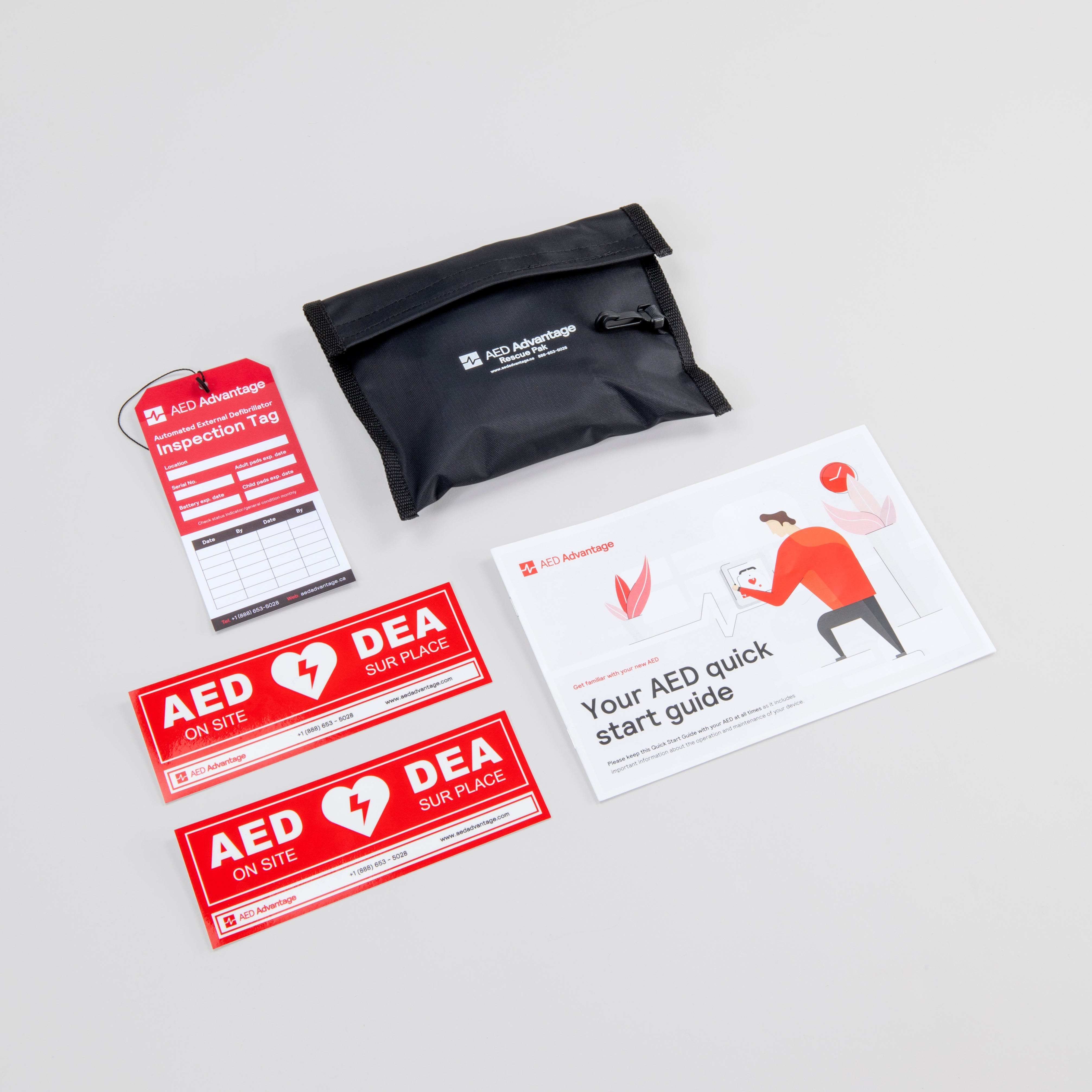 A red AED inspection tag, black rescue kit, two red door decals, and an AED quick start guide booklet.