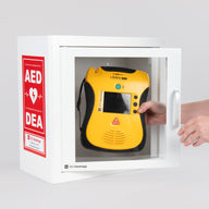 A yellow and black Defibtech Lifeline VIEW AED being retrieved by hand from a white metal cabinet with red decals