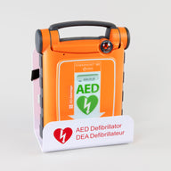 An orange Powerheart G5 AED displayed in a white metal wall mount bracket.