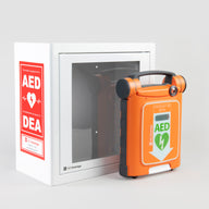An orange Powerheart G5 AED standing in front of a white metal cabinet with red decals