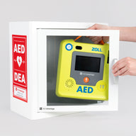 A green ZOLL AED 3 machine being retrieved by hand from a white metal cabinet with red decals